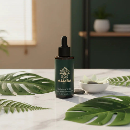 Mamba hair growth oil bottle on a table with green leaves and a blurred background