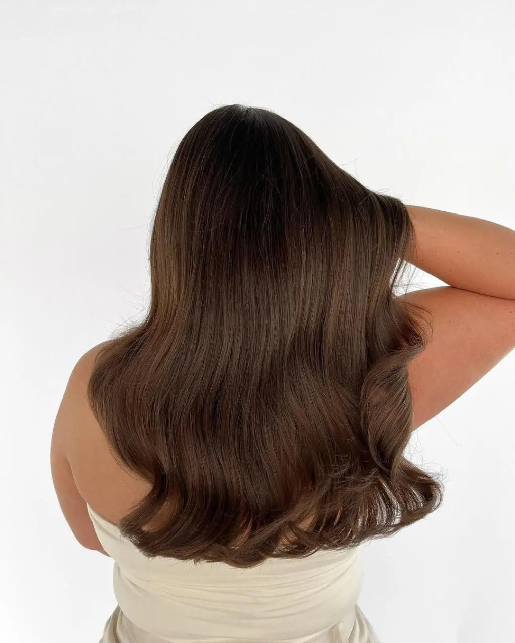 Person with long, wavy brown hair on a white background